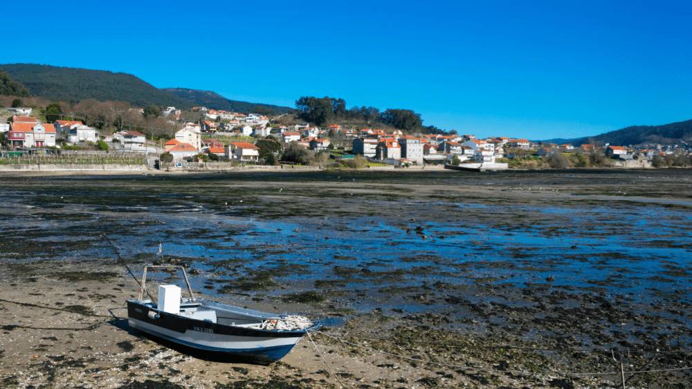 Loď v suchej časti ústia rieky Pontevedra (Španielsko).
